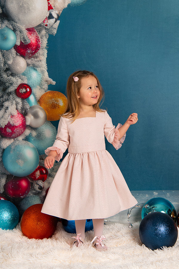 Robe de fête et cérémonie pour petite fille en tissu broché rose et or de fabrication française. Photo de la robe portée par une petite fille.