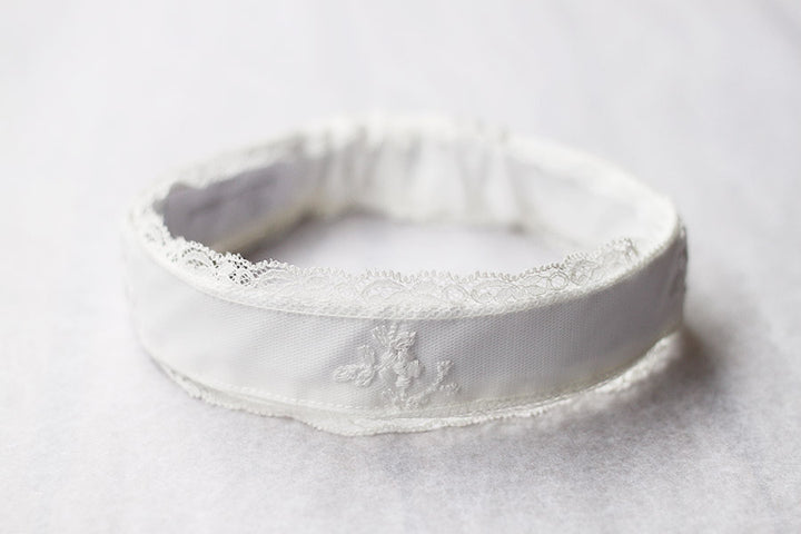 Bandeau cheveux cérémonie bébé fille en coton, tulle brodé et dentelle blanc cassé. A porter pour un baptême ou une cérémonie. Photo du gros plan du bandeau.