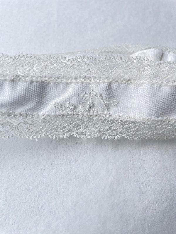 Bandeau cheveux cérémonie bébé fille en coton, tulle brodé et dentelle blanc cassé. A porter pour un baptême ou une cérémonie. Photo du gros plan de la broderie.