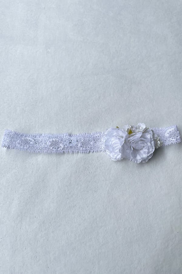 Bandeau cheveux pour bébé fille en dentelle et fleurs blanches. A porter pour un baptême ou une cérémonie. Photo du bandeau posé à plat.