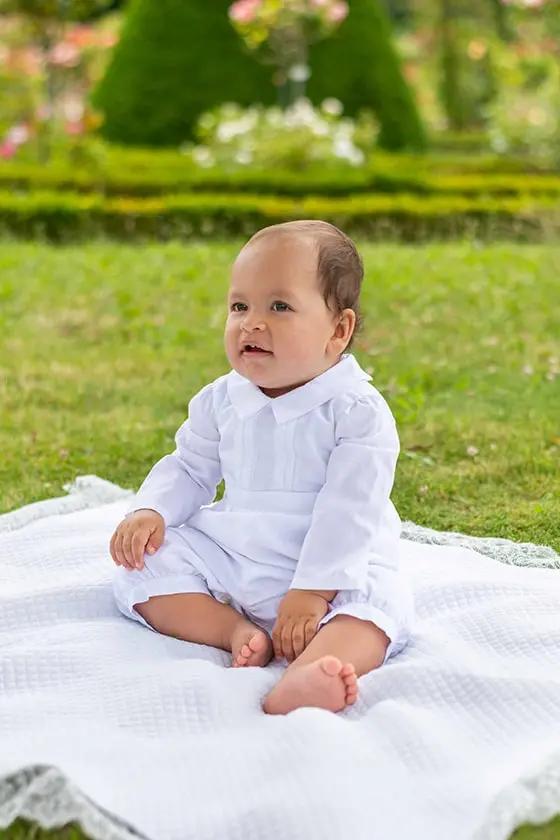 Barboteuse baptême bébé garçon Léo en coton blanc et dentelle de coton. Création française Fil de Légende. Photo de la barboteuse portée pas un bébé garçon.