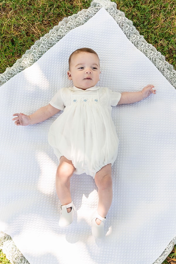 Barboteuse baptême cérémonie bébé garçon été en mousseline avec smocks. Modèle Louis. Création française Fil de Légende. Photo de la barboteuse portée par un bébé.