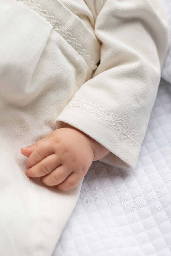 Barboteuse baptême bébé garçon Paul pour l'hiver en velours de coton doublée polaire. Création française Fil de Légende. Photo de la manche.