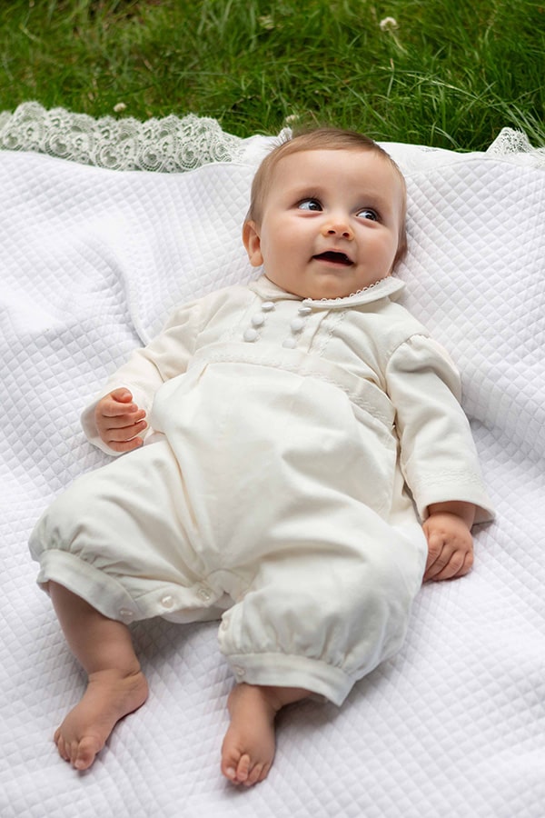 Barboteuse baptême bébé garçon Paul pour l'hiver en velours de coton doublée polaire. Création française Fil de Légende. Photo de la barboteuse portée par un bébé garçon allongé