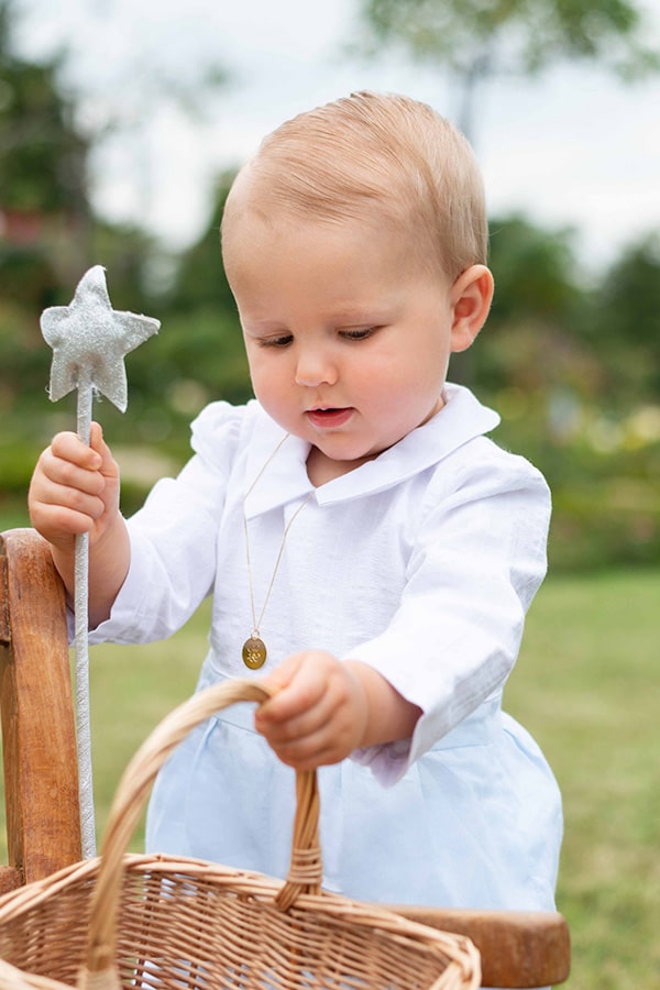 Barboteuse cérémonie bébé garçon Hugo. Corsage en coton brodé blanc. Pantalon en coton bleu ciel. Création française Fil de Légende. Photo de la barboteuse portée par un bébé garçon.