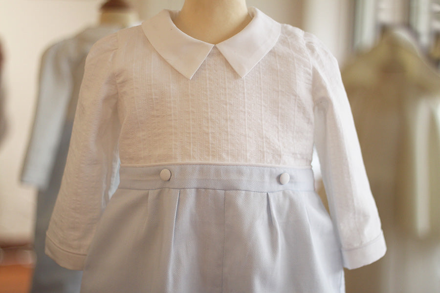 Barboteuse cérémonie bébé garçon Hugo. Corsage en coton brodé blanc. Pantalon en coton bleu ciel. Création française Fil de Légende. Photo du devant du corsage.