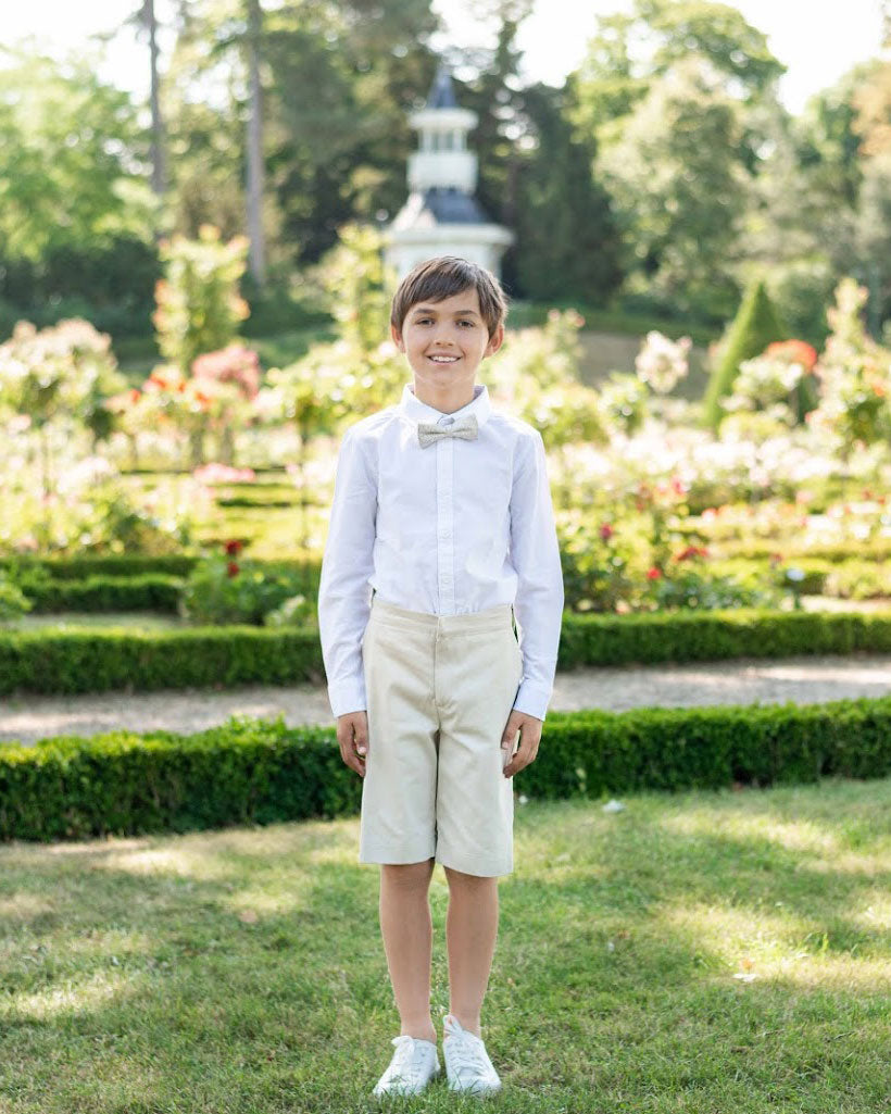 Bermuda de cérémonie pour garçon en coton beige. Création française Fil de Légende. Disponible en ligne et en boutique à Paris, Neuilly-sur-Seine.