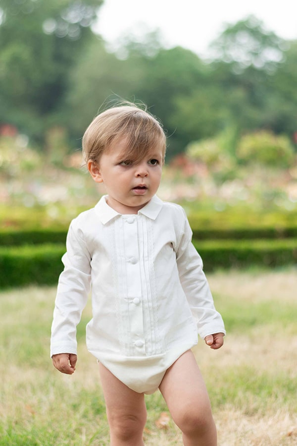 Body chemise de cérémonie pour bébé garçon Oscar en popeline de coton blanc cassé et dentelle de coton. Création française Fil de Légende. Photo du body chemise porté par un bébé garçon.