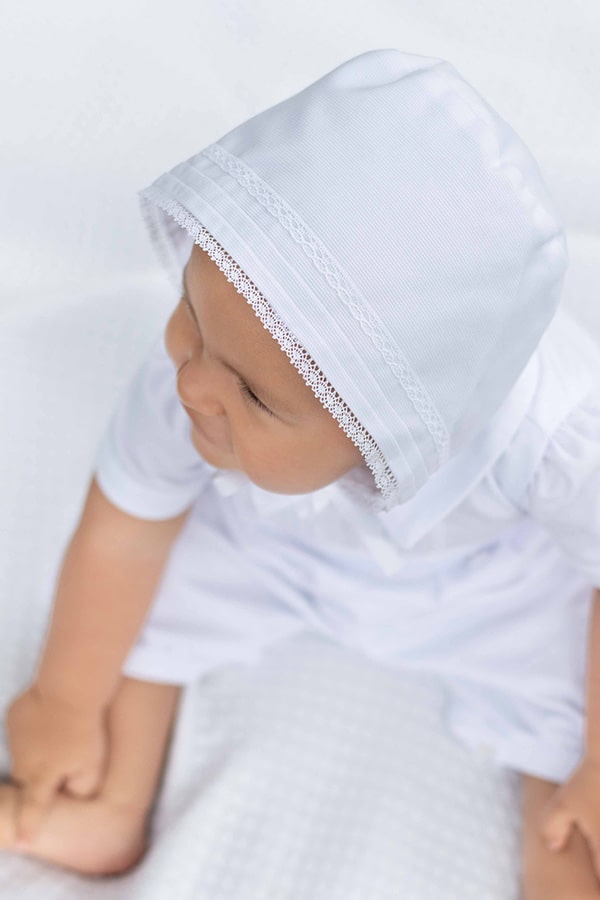 Bonnet de baptême bébé garçon Augustin en piqué de coton blanc et dentelle de coton. Création française Fil de Légende. Photo du bonnet vu du dessus.