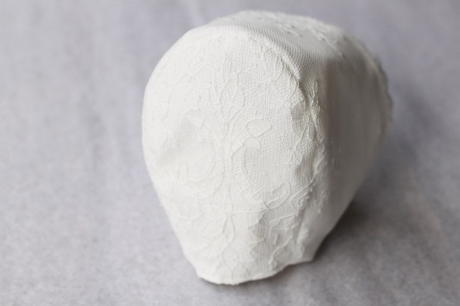 Bonnet de baptême traditionnel pour bébé en dentelle fine. Couleur blanc cassé. Fait main en France. Vue de dos.