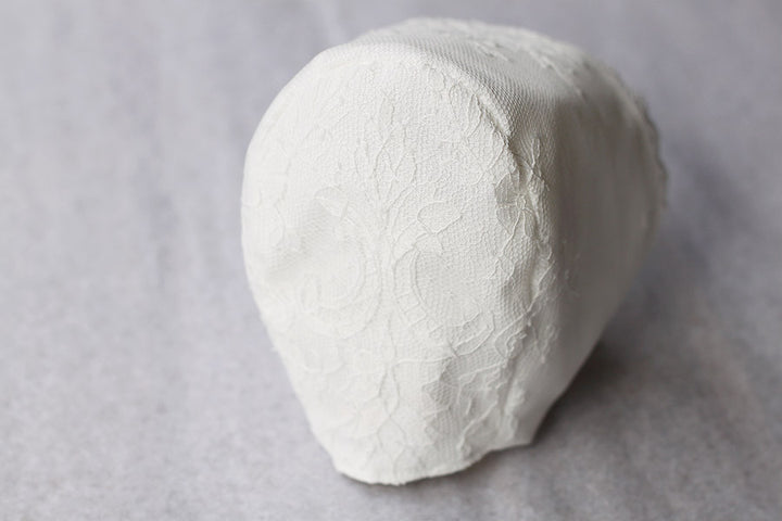 Bonnet de baptême traditionnel pour bébé en dentelle fine. Couleur blanc cassé. Fait main en France. Vue de dos.