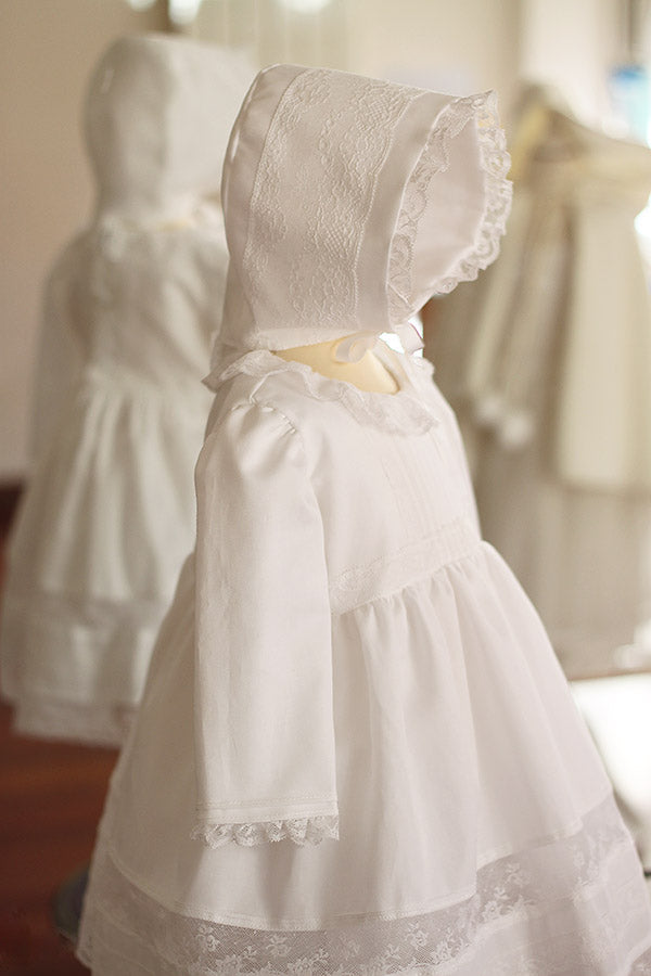 Bonnet baptême bébé fille Marie en coton blanc et dentelle de Calais. Création française Fil de Légende. Photo du bonnet vu de côté.