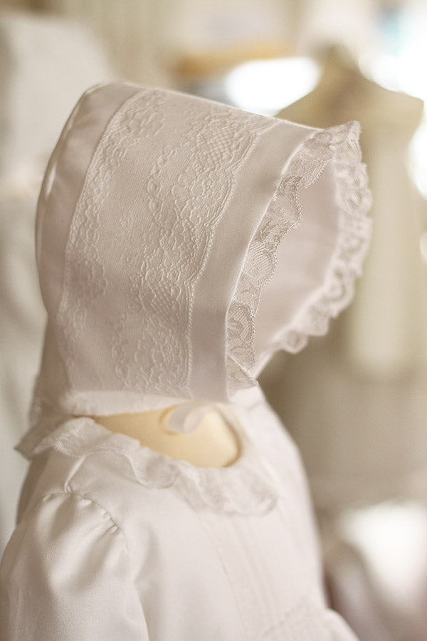 Bonnet baptême bébé fille Marie en coton blanc et dentelle de Calais. Création française Fil de Légende. Photo du gros plan du bonnet.
