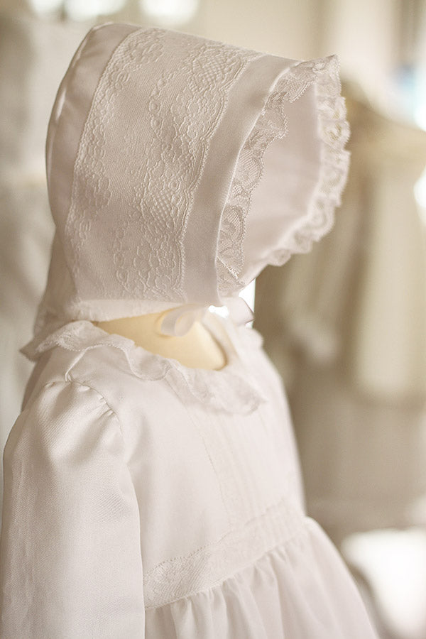 Bonnet baptême bébé fille Marie en coton blanc et dentelle de Calais. Création française Fil de Légende. Disponible en ligne et en boutique à Paris, Neuilly-sur-Seine.
