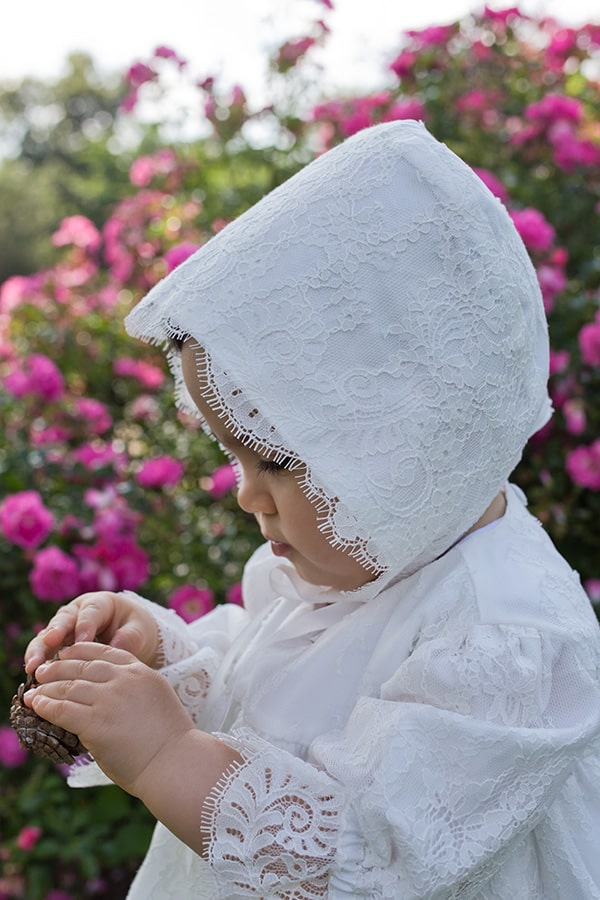 Bonnet de baptême bébé fille Amaia en dentelle italienne doublé coton. Création française Fil de Légende. Photo du bonnet vu de côté.