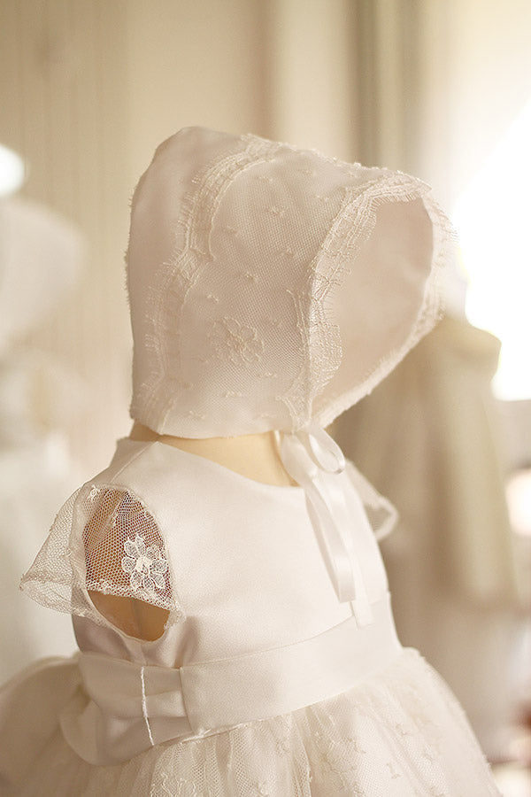 Bonnet de baptême bébé fille Maya en satin italien blanc cassé et dentelle française de calais Caudry. Création française Fil de Légende. Disponible en ligne et en boutique à Paris, Neuilly-sur-Seine.