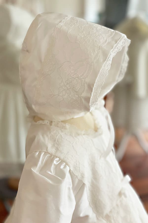Bonnet de baptême pour bébé fille en soie et dentelle blanc cassé. Photo de la dentelle du bonnet.
