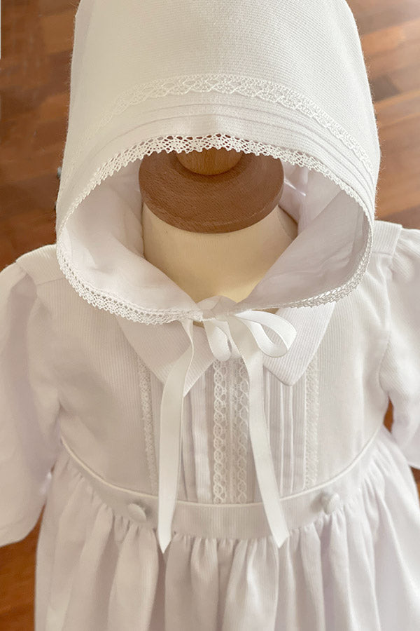 Bonnet de baptême bébé pour fille ou garçon en piqué de coton blanc et dentelle de coton. Modèle Gabriel. Photo rapprochée du bonnet.