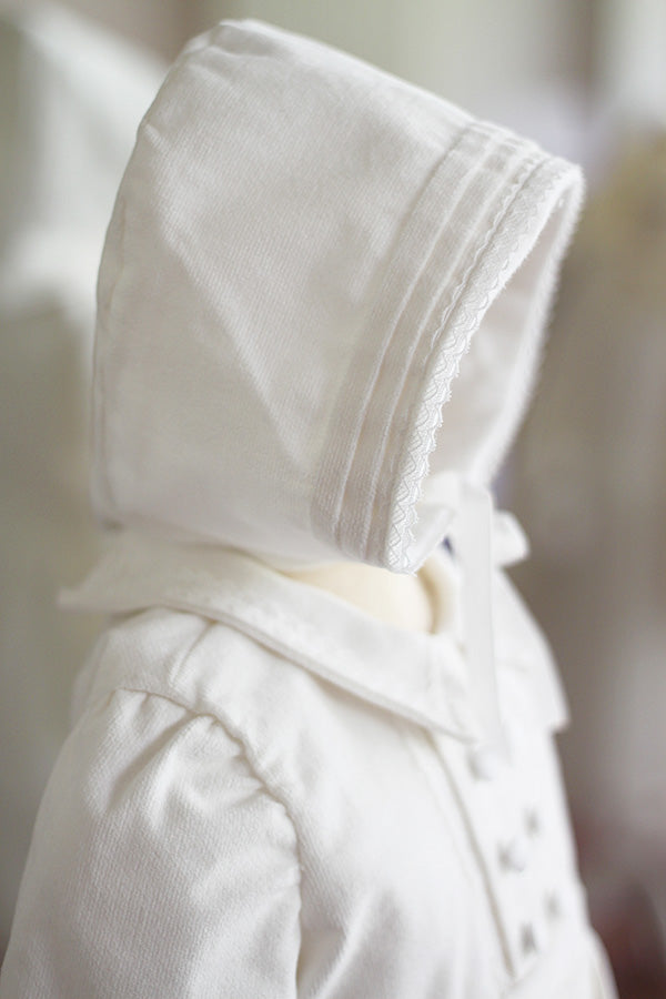 Bonnet baptême bébé garçon Paul pour l'hiver en velours de coton blanc cassé et galon de dentelle de coton. Création française Fil de Légende. Disponible en ligne et en boutique à Paris, Neuilly-sur-Seine.