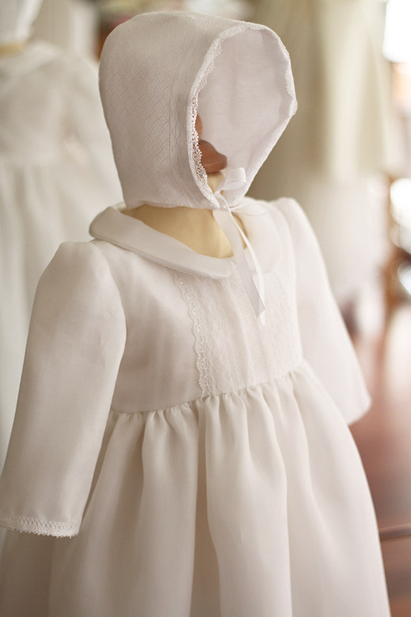 Bonnet de baptême bébé Victor en organza de soie blanc et dentelle blanche. Création française Fil de Légende. Photo du côté du bonnet.