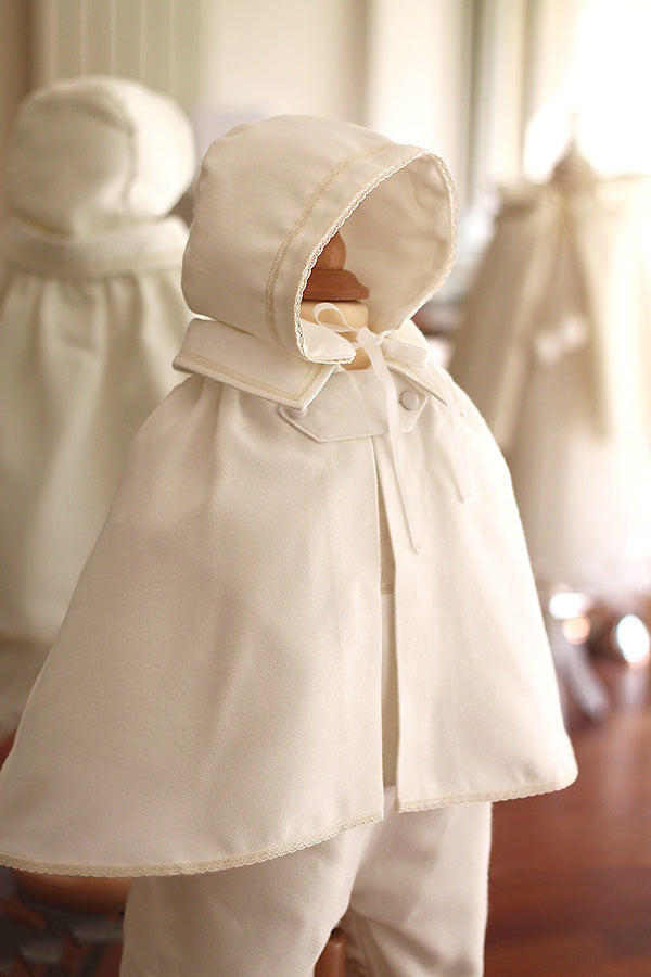 Bonnet de baptême bébé garçon Thomas pour l'hiver en lainage et galon de dentelle de coton. Création française Fil de Légende. Photo du bonnet porté avec la cape assortie.