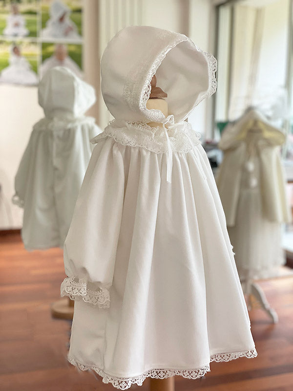 Bonnet baptême bébé fille pour l'hiver en velours blanc cassé et dentelle. Doublure polaire. Création française Fil de Légende. Photo du bonnet porté avec la robe assortie.