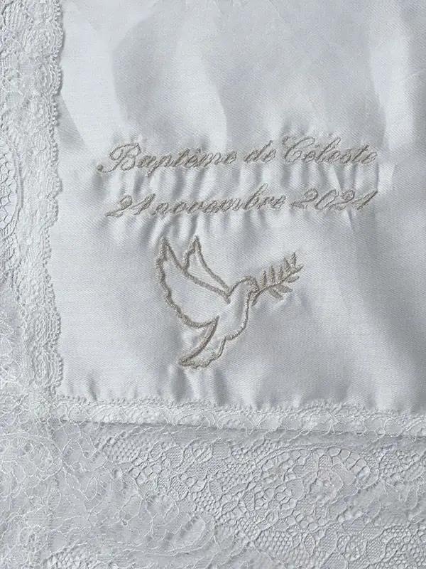 Broderies baptême prénom et date du baptême en fil beige sur un châle de baptême. Boutique Fil de Légende à Paris, Neuilly-sur-Seine.