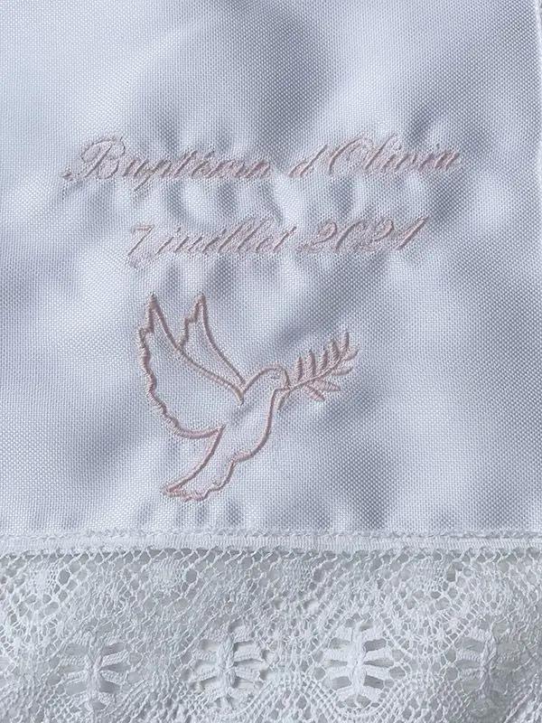 Broderies baptême prénom et date du baptême en fil rose sur un châle de baptême. Boutique Fil de Légende à Paris, Neuilly-sur-Seine.