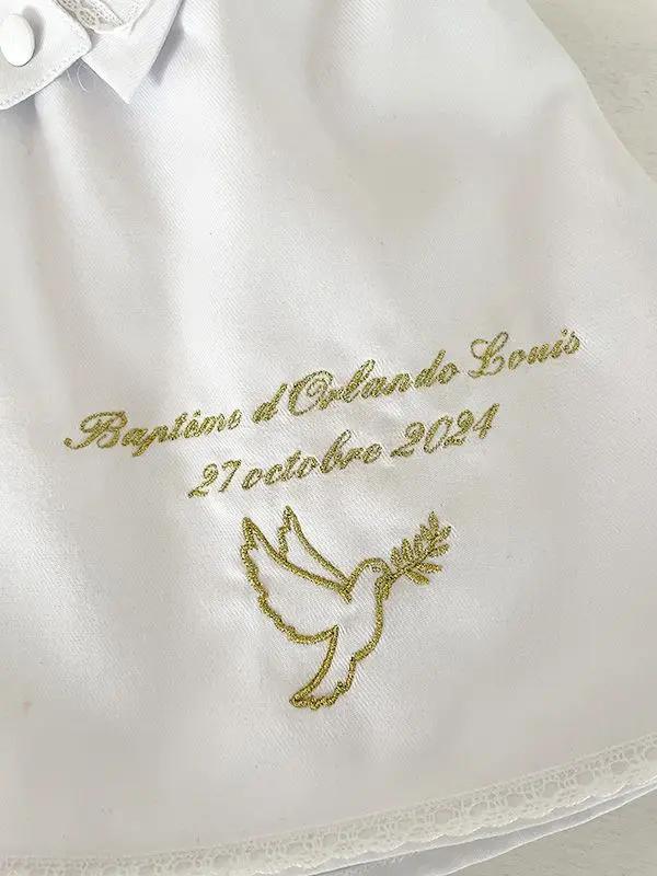 Broderies baptême prénom et date du baptême en fil doré sur une cape de baptême. Boutique Fil de Légende à Paris, Neuilly-sur-Seine.