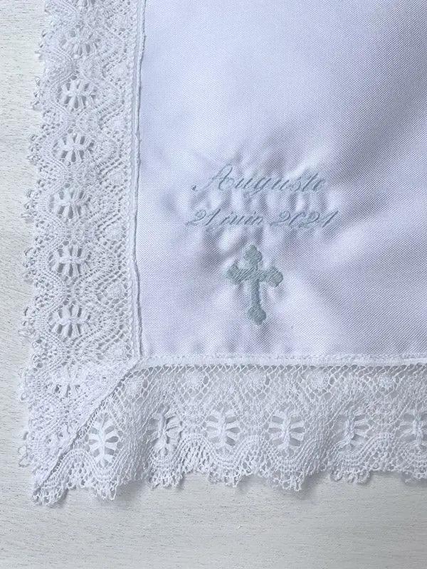 Broderies baptême prénom et date du baptême en fil bleu ciel sur un châle de baptême. Boutique Fil de Légende à Paris, Neuilly-sur-Seine.