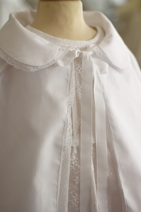 Cape de baptême bébé fille en coton blanc et galon de dentelle. Création française Fil de Légende. Photo du col de la cape.