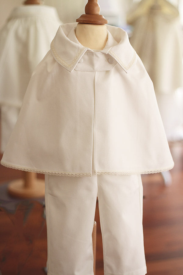 Cape de baptême bébé garçon Oscar en coton blanc cassé et galons de dentelle de coton. Création française Fil de Légende. Disponible en ligne et en boutique à Paris, Neuilly-sur-Seine. 