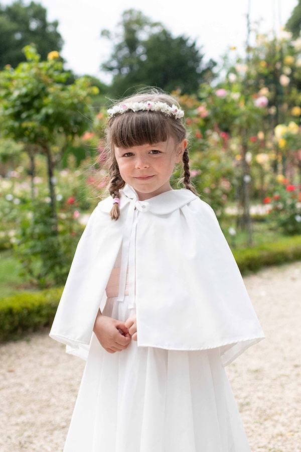 Cape de baptême bébé en coton blanc cassé. Création française Fil de Légende.  Photo de la cape portée par une petite fille.