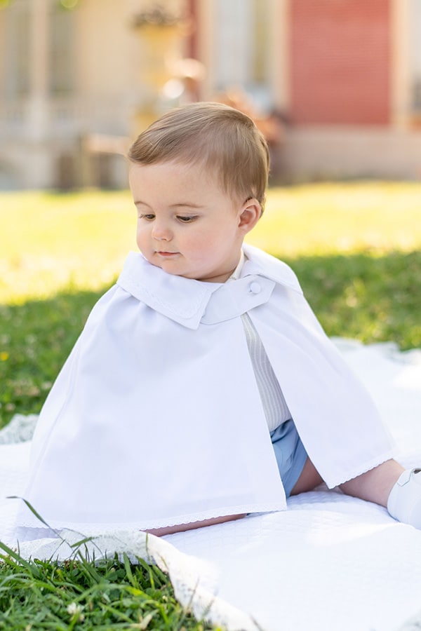 Cape de baptême bébé garçon Adrien en coton blanc et dentelle de coton.  Création française Fil de Légende. Photo de la cape portée, vue de côté.