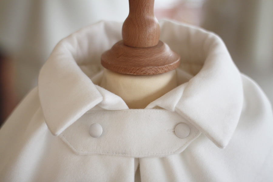 Cape de baptême bébé garçon Paul pour l'hiver en mouflon doublé polaire. Création française Fil de Légende. Photo de la patte de boutonnage. 