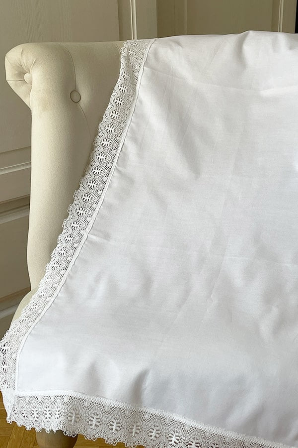 Châle de baptême bébé en coton blanc bordé d'un large galon de dentelle de coton. Photo du châle déplié.