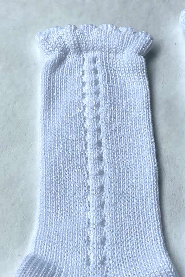 Chaussettes hautes bébé à porter avec une barboteuse bébé - Ajourées en coton blanc - gros plan -Fil de Légende Paris, Neuilly-sur-Seine