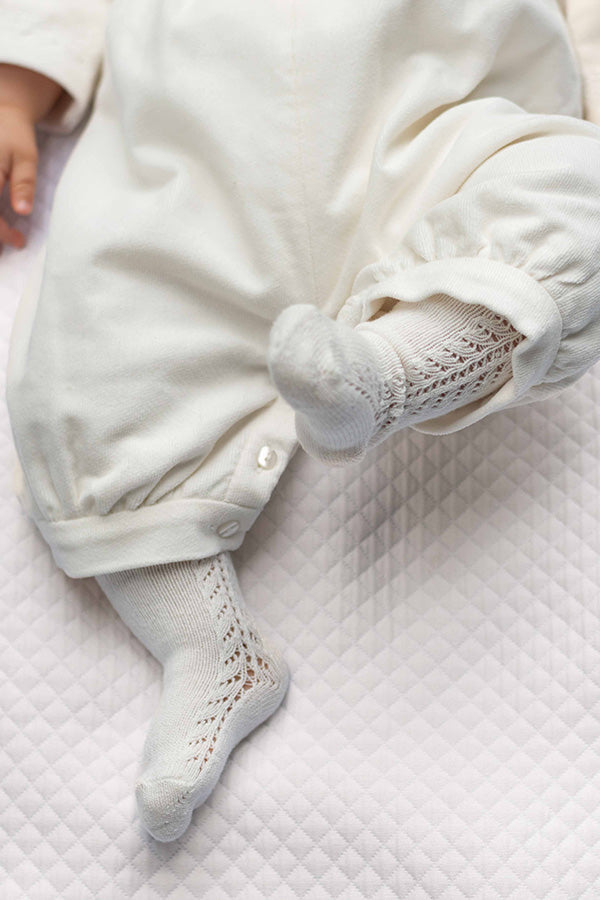 Chaussettes hautes bébé en coton chaud blanc cassé. A porter avec une barboteuse au printemps ou à l'automne - Exemple sur un bébé