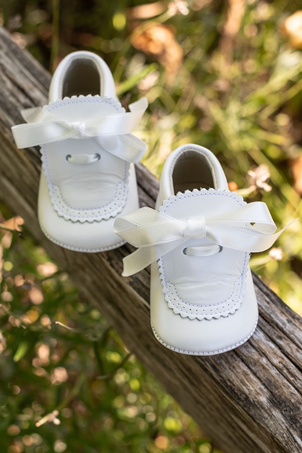 Chaussons montants bébé fille pour  cérémonie ou baptême - en cuir blanc cassé avec une décoration raffinée et un joli nœud en satin -  vue du dessus à l'extérieur