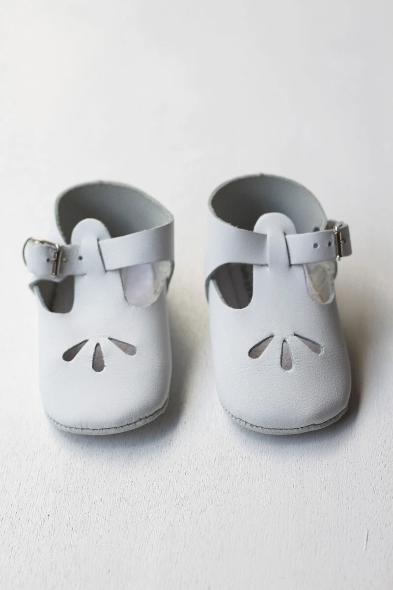 Chaussons cérémonie baptême bébé en cuir blanc. Idéal pour la saison printemps/ été. Ouverture à boucle. Magasin Fil de Légende Paris, Neuilly-sur-Seine.