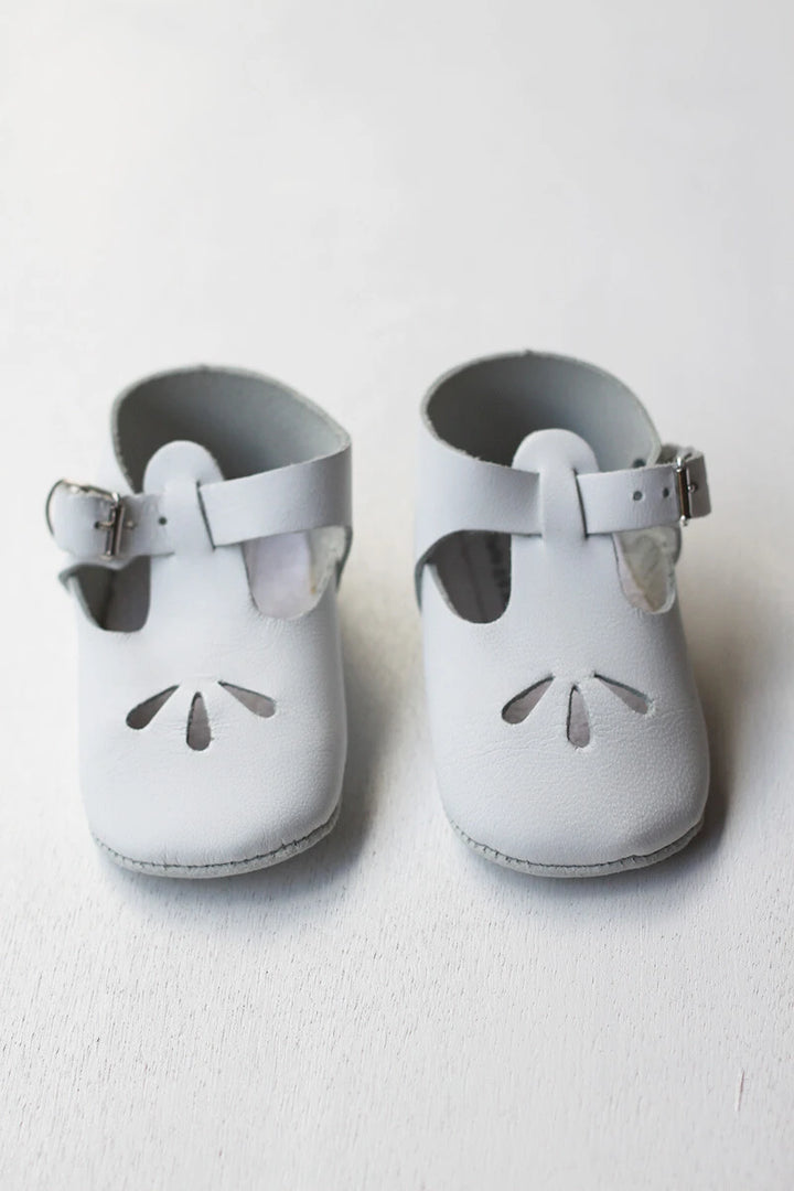 Chaussons cérémonie baptême bébé en cuir blanc. Idéal pour la saison printemps/ été. Ouverture à boucle. Magasin Fil de Légende Paris, Neuilly-sur-Seine.