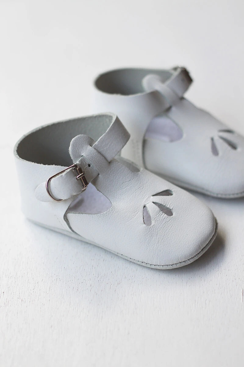 Chaussons cérémonie baptême bébé en cuir blanc. Idéal pour la saison printemps/ été. Ouverture à boucle. Vue de côté.