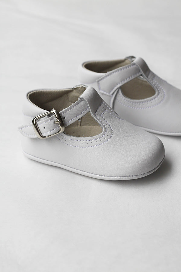 Chaussons baptême cérémonie bébé fille ou garçon pour l'été. Chaussons en cuir blanc avec une ouverture à boucle. Vue de côté.