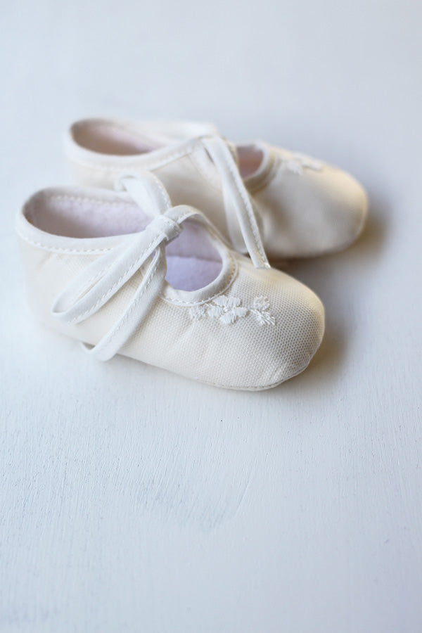 Chaussons ballerines bébé fille en tulle brodé ivoire pour cérémonie ou baptême. Vue de côté.