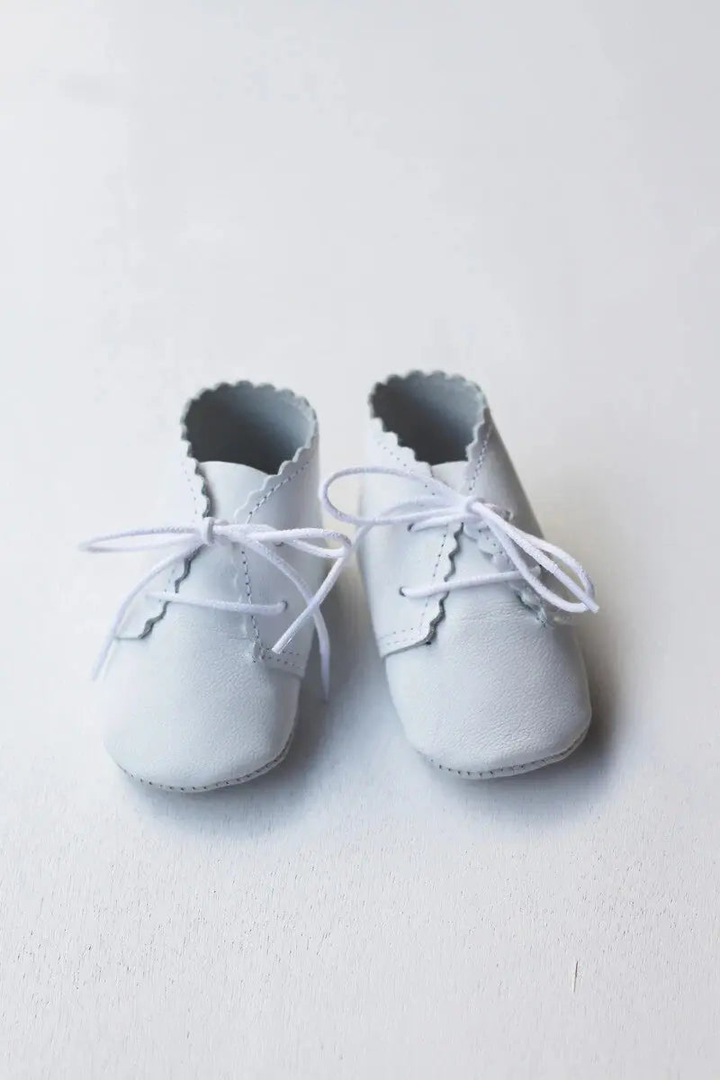 Chaussons montants bébé fille ou garçon en cuir souple blanc. Idéal pour baptême. Photo des chaussons vue de face.