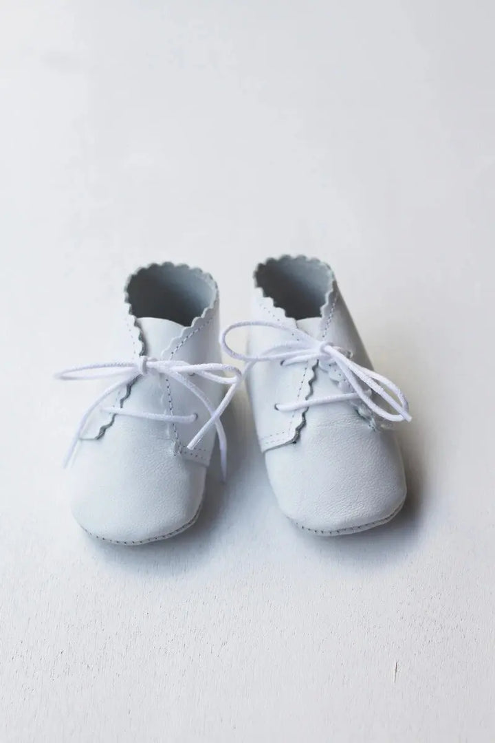 Chaussons montants bébé fille ou garçon en cuir souple blanc. Idéal pour baptême. Photo des chaussons vue de face.