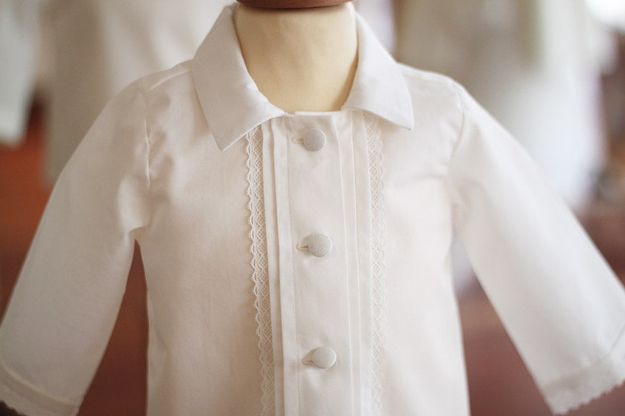 Chemise cérémonie bébé garçon Oscar en popeline de coton blanc cassé et dentelle de coton. Création française Fil de Légende. Photo de la chemise sur un mannequin de couture.