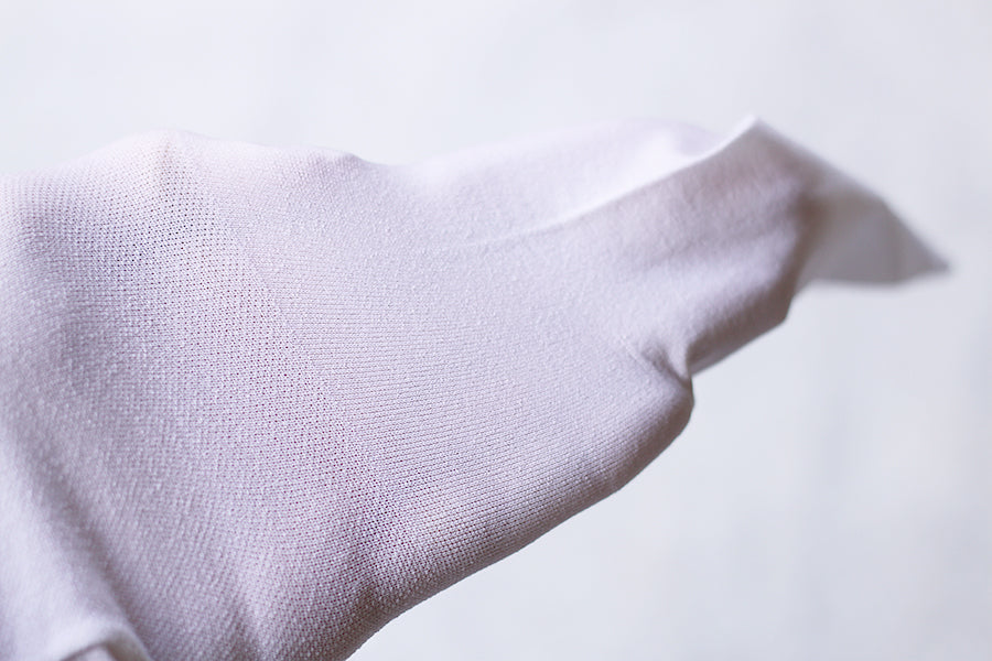 Collant fin blanc pour bébé fille, de type collant de danse. Idéal à porter avec une robe de cérémonie. Photo de la texture du collant.