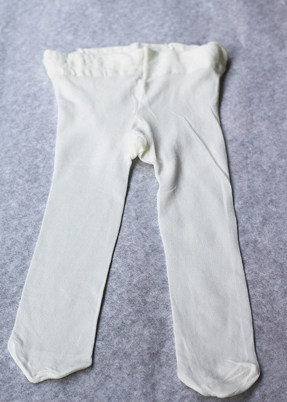 Collant fin bébé fille ivoire de type collant de danse, idéal à porter avec une robe de cérémonie. Boutique Fil de Légende à Paris, Neuilly-sur-Seine.