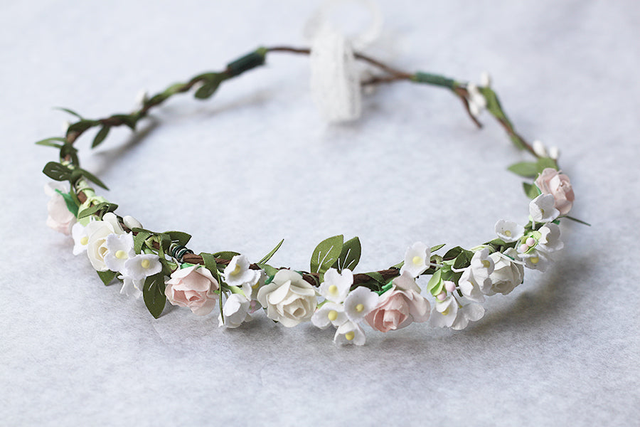 Couronne de fleurs artificielles blanche et rose pâle pour petites filles à porter pour accessoiriser une robe de cérémonie pour enfant et sublimer une coiffure.